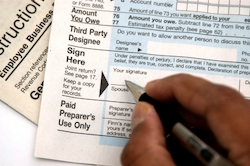 Picture of a person filling our tax forms
