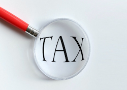 Picture of a magnifying glass over the word Tax